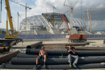 Рабочие отдыхают на фоне строящегося Олимпийского стадиона "Фишт"