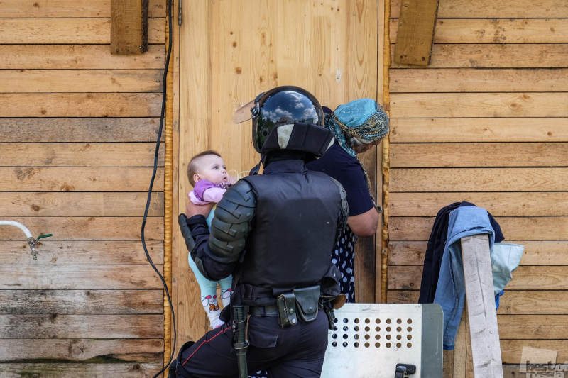 Сотрудник ОМОН с ребенком во время сноса незаконных построек в цыганском поселке в Плеханово Тульской области
