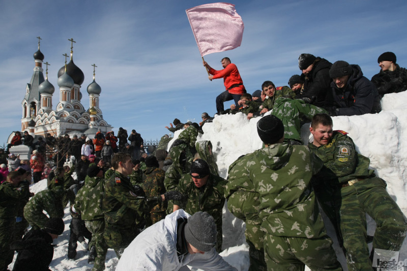 Взятие снежного городка во время праздника Масленица.